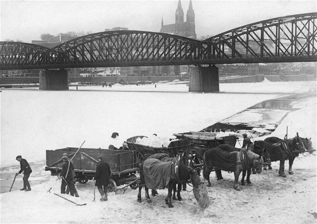 Povozy leda na vltavském nábeí v Praze roku 1929. V pozadí elezniní most